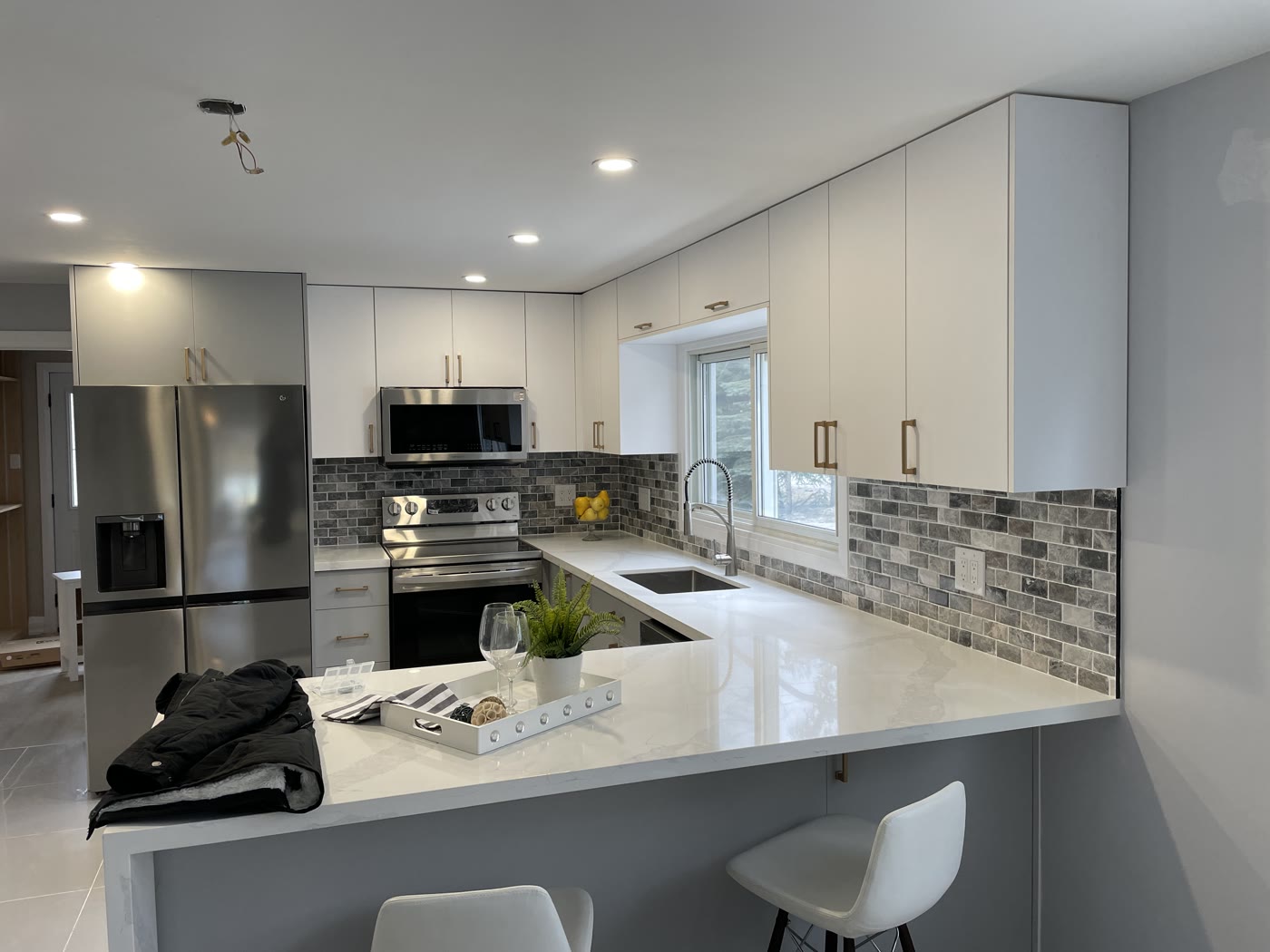 Modern kitchen renovation with white cabinets and quartz countertop